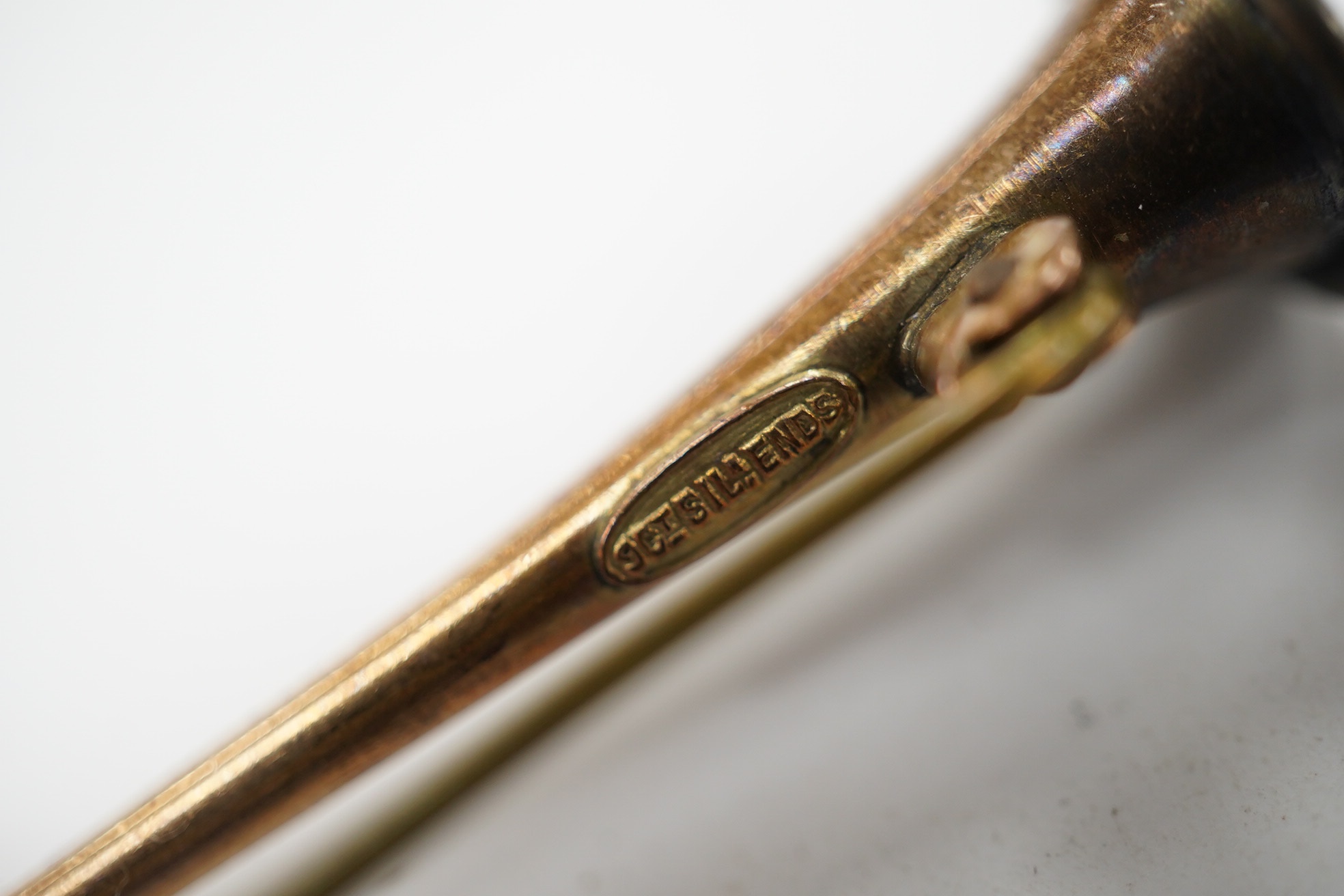 A '9ct and silver' hunting horn bar brooch, 62mm, together with a 1930's yellow metal brooch, with engraved inscription. Condition - fair